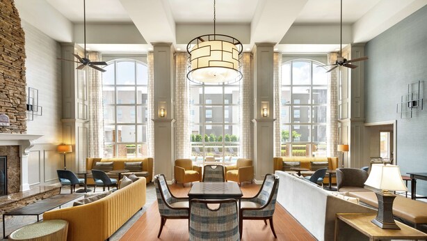 A spacious lobby with a central seating area, large windows, and a fireplace. - Hampton Inn & Suites Montgomery-EastChase (Montgomery)