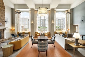 A spacious lobby with a central seating area, large windows, and a fireplace.