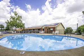 Una piscina al aire libre, tumbonas