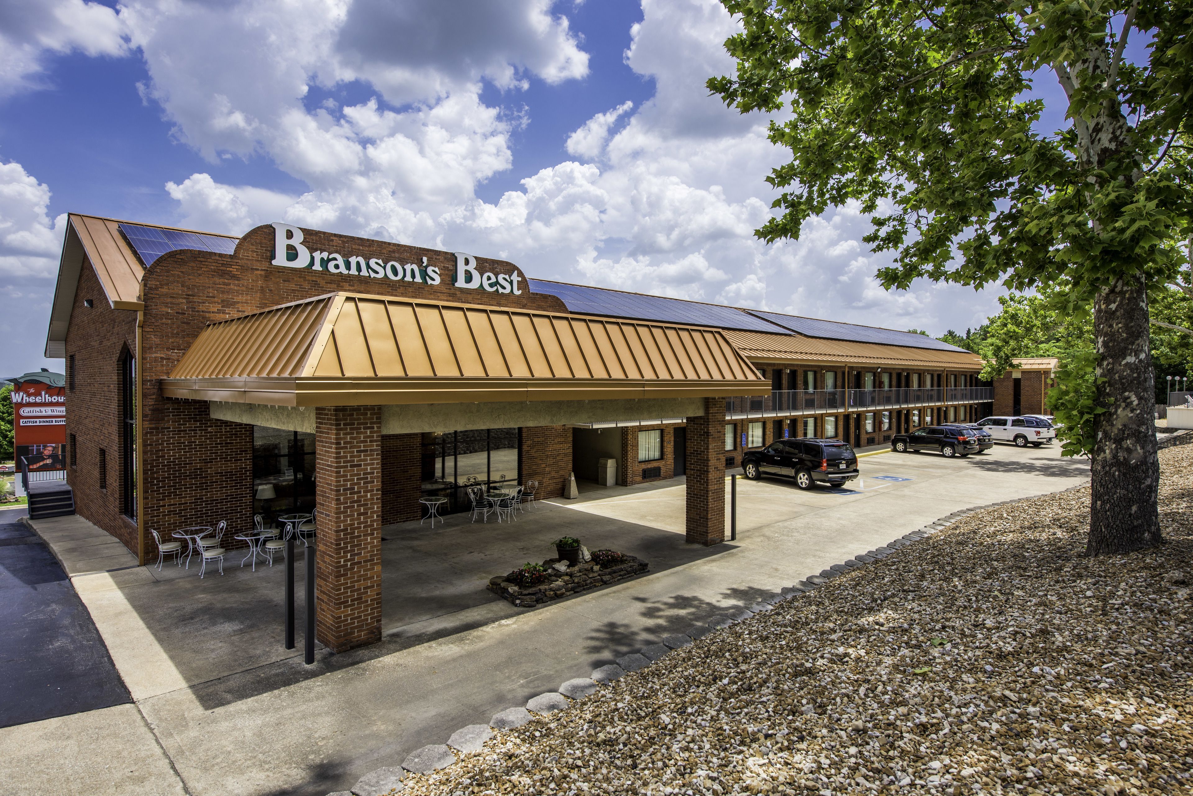 Een gebouw met een bord waarop "Branson's Best" staat en een overdekt terras met tafels en stoelen.