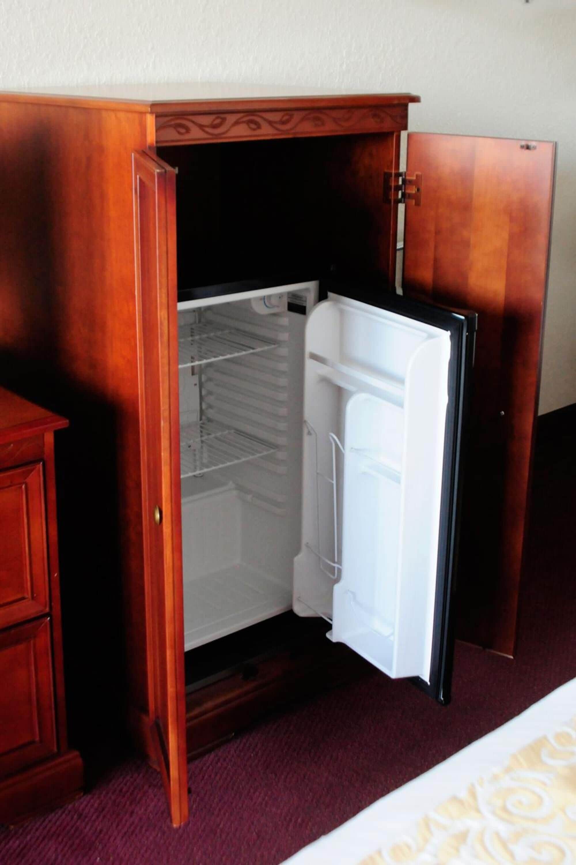 A compact wooden cabinet with a built-in refrigerator, featuring a single door and a shelf.