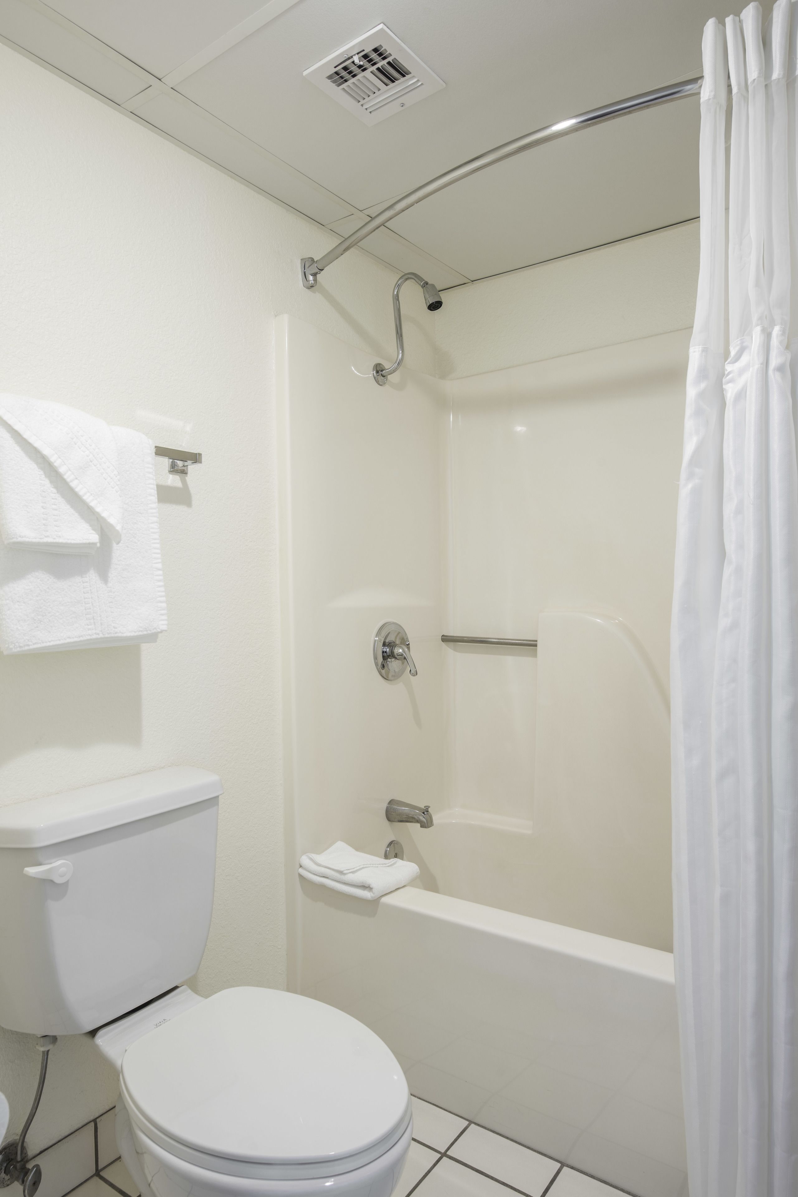 A bathroom with a toilet, a shower, and a bathtub.