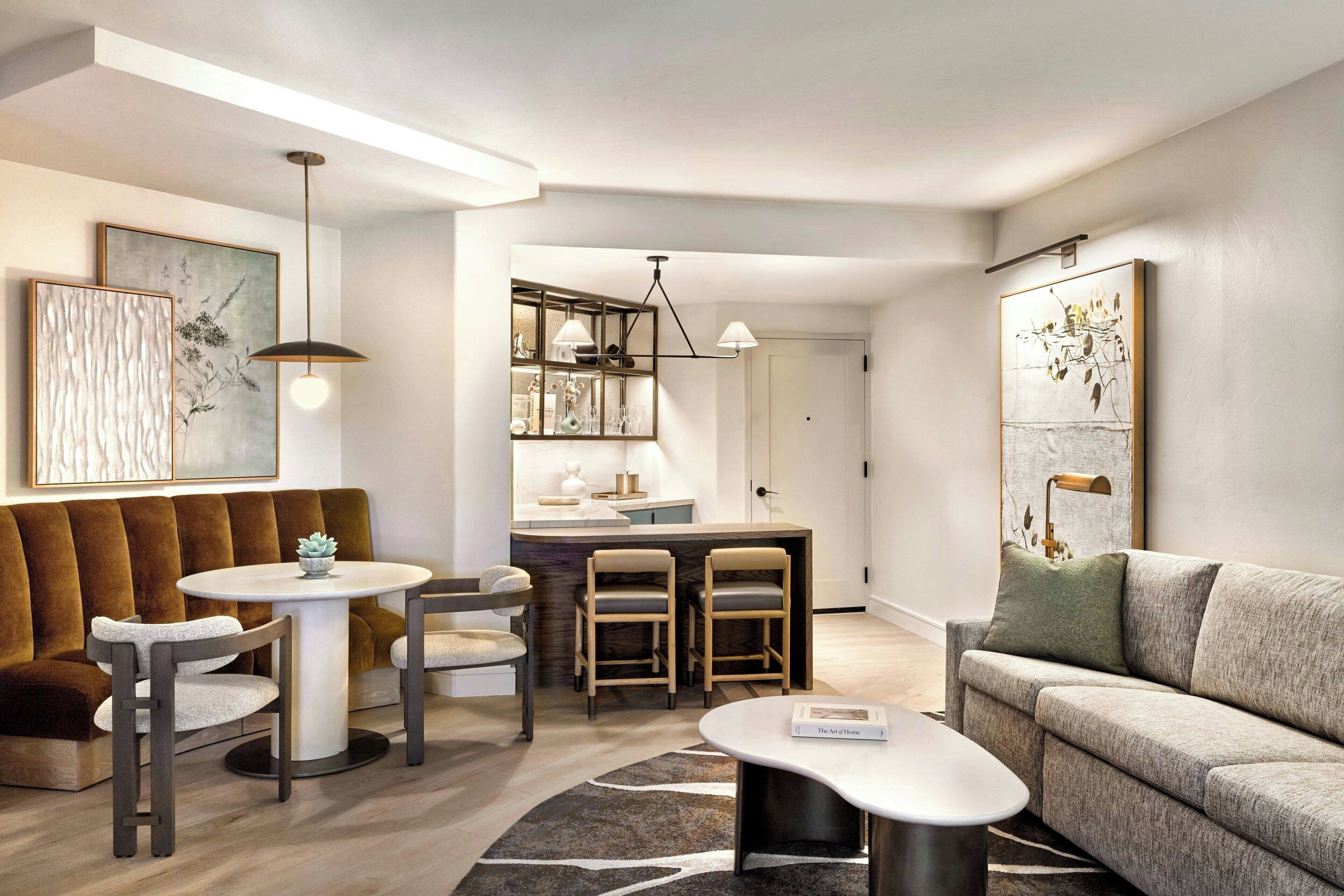 A modern living room with a sofa, a round coffee table, and a dining area with a small table and chairs.