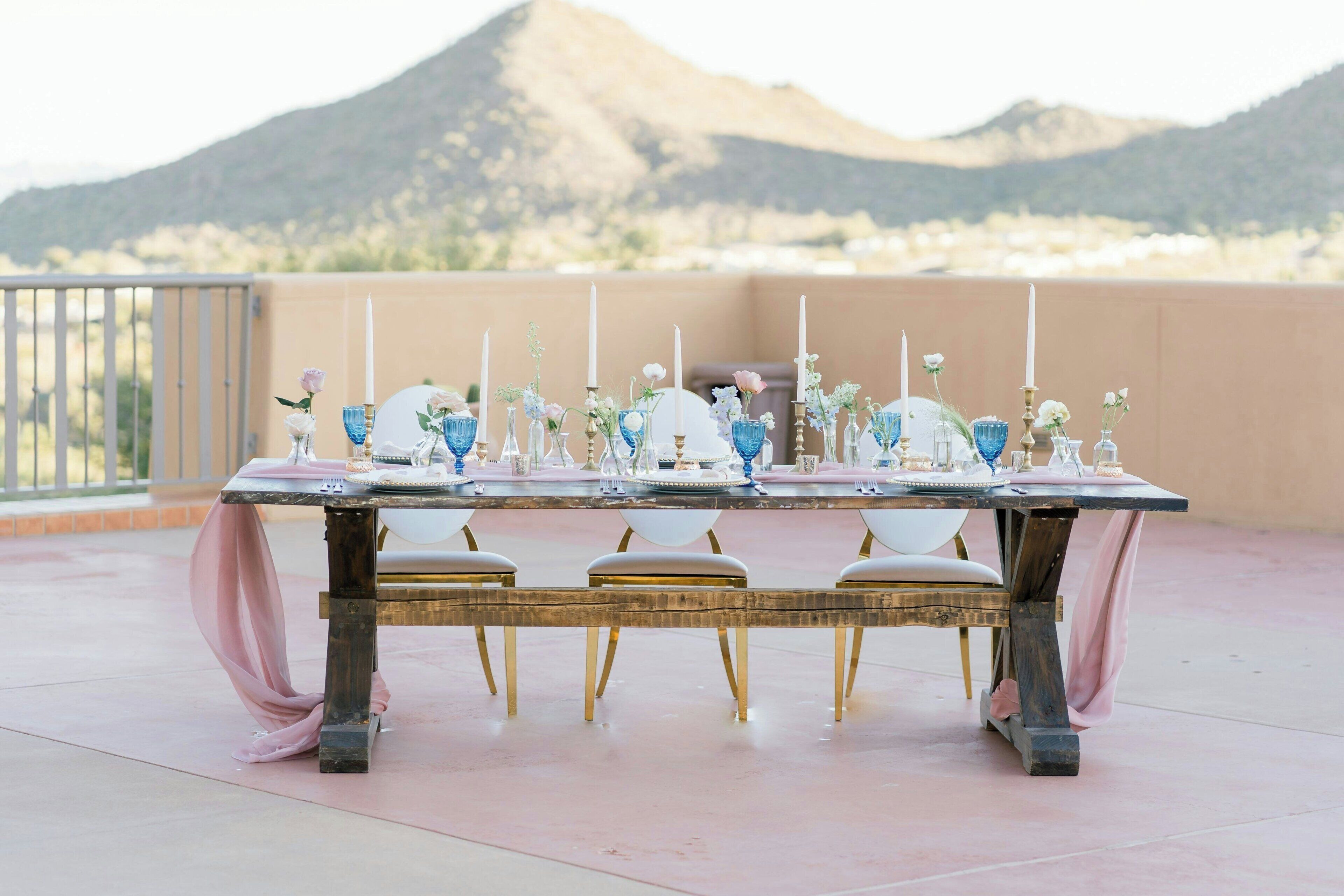 A table set outdoors with a mountain backdrop.