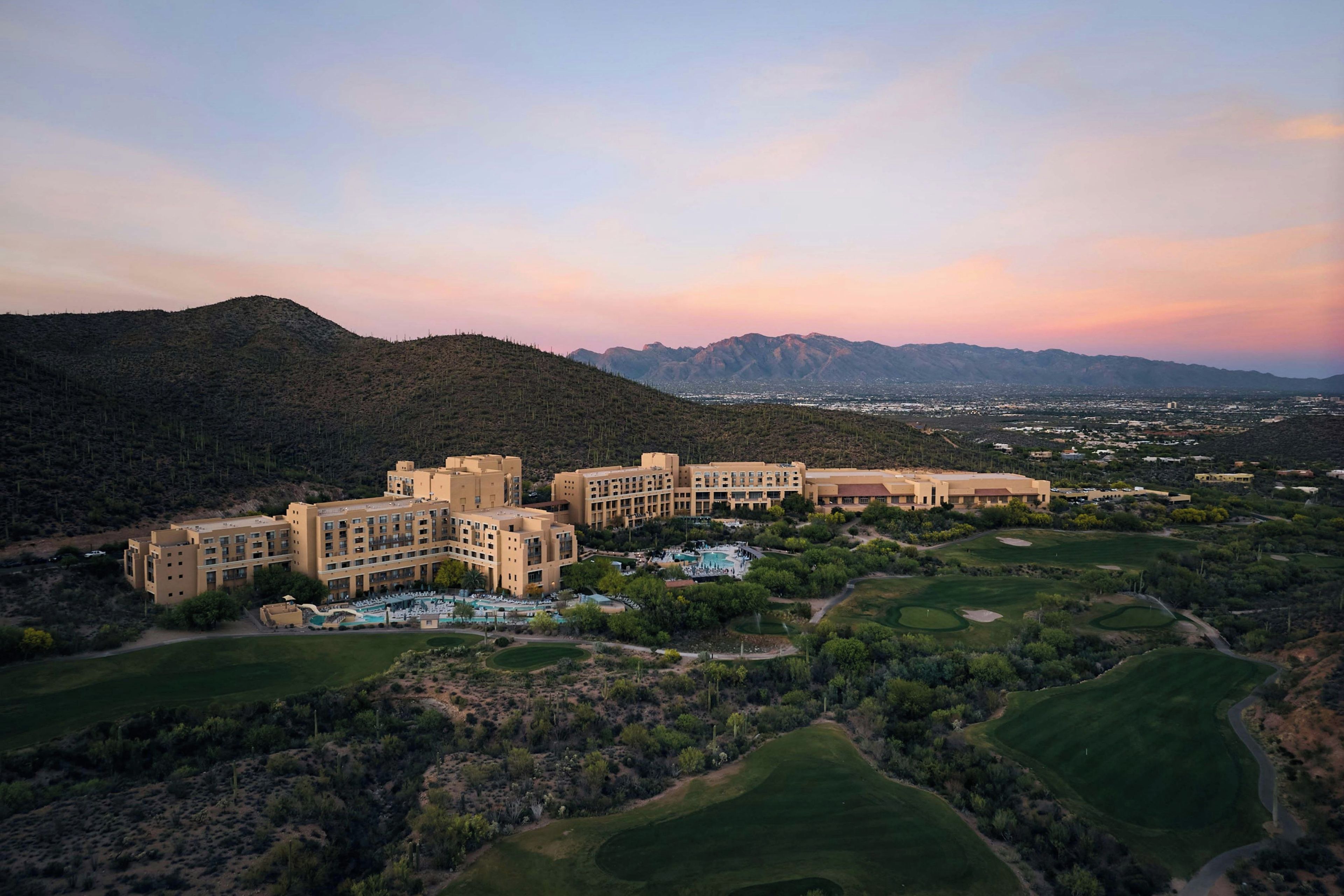 A resort with multiple buildings, a pool area, and golf courses.