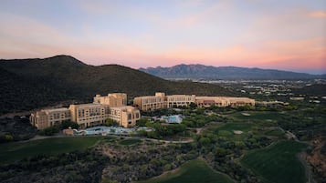 A resort with multiple buildings, a pool area, and golf courses.