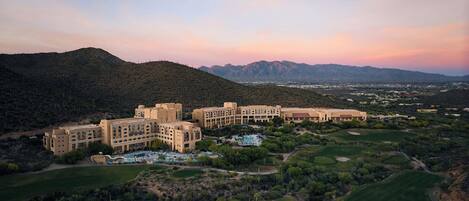 A resort with multiple buildings, a pool area, and golf courses.
