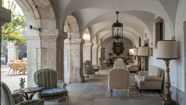 A spacious interior with arched ceilings, a chandelier, and classic furniture. - Pousada Castelo de Palmela - Historic Hotel (Palmela)