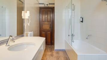 A bathroom with a sink, mirror, and shower.