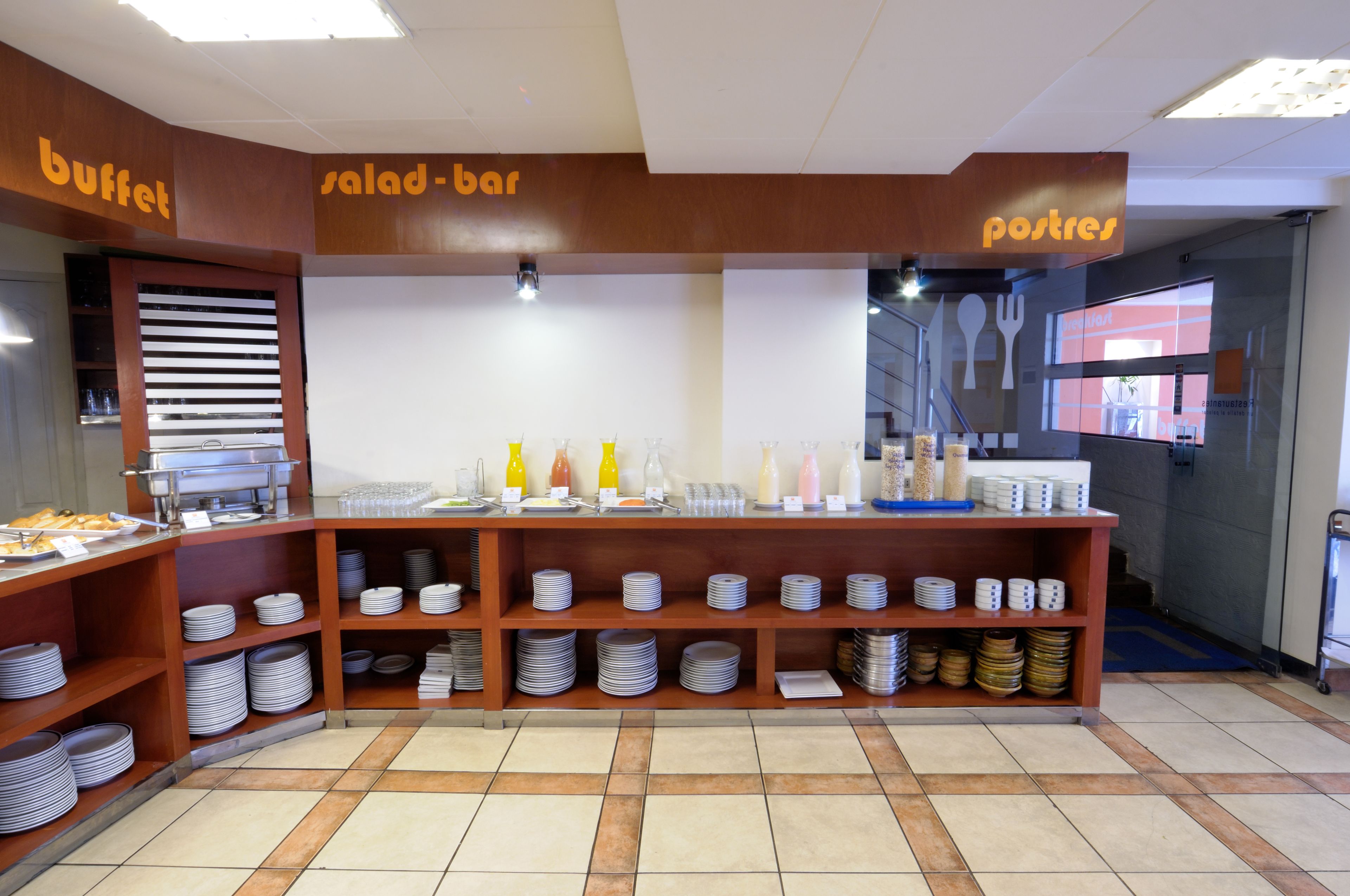 Uma área de buffet com seções identificadas para buffet, bar de saladas e sobremesas.
