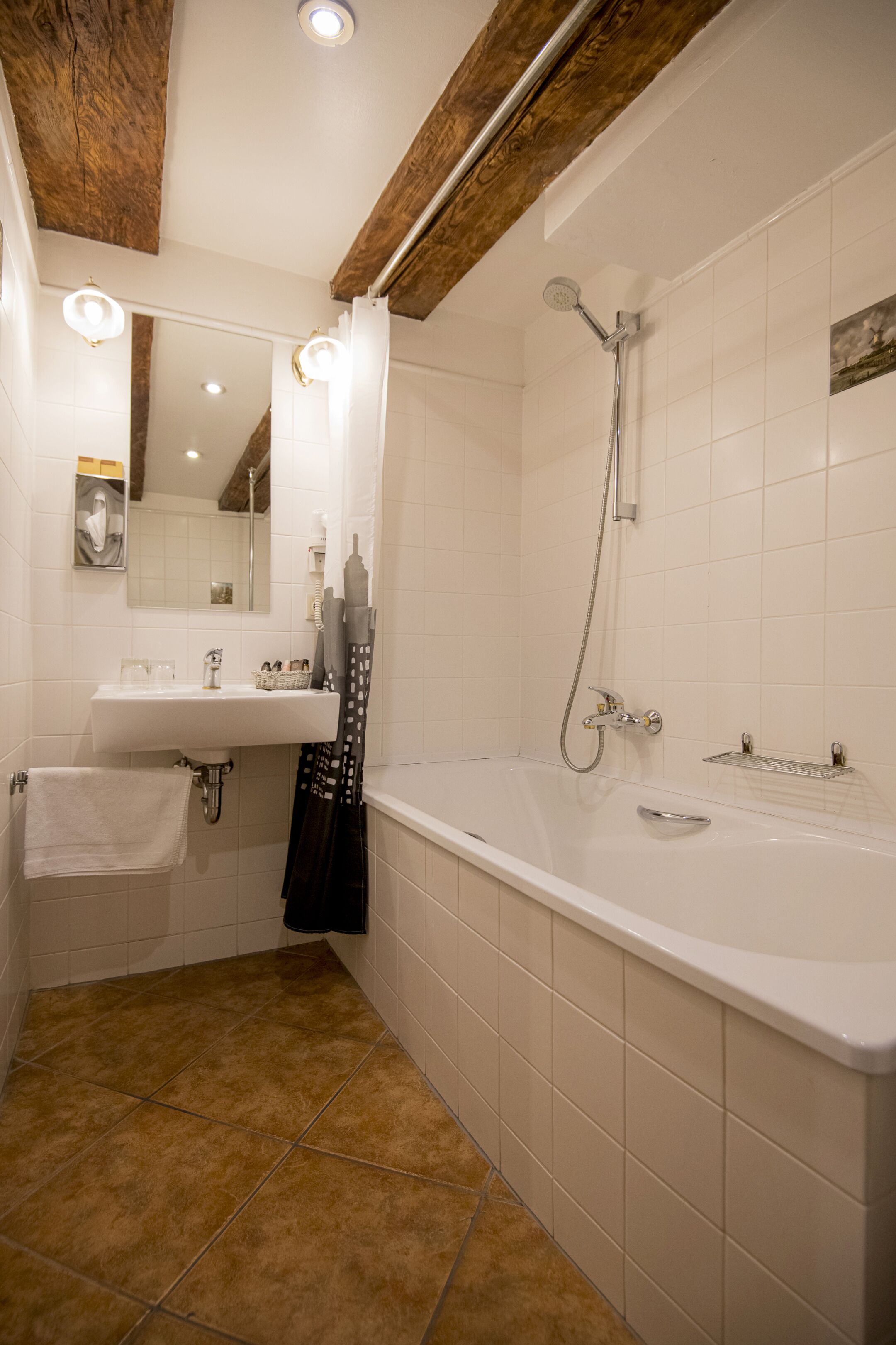 A bathroom with a white sink, mirror, and bathtub.