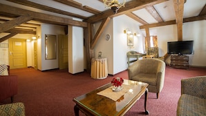 A spacious living room with exposed wooden beams, a television, and comfortable seating. - Gutenbergs Hotel (Riga)