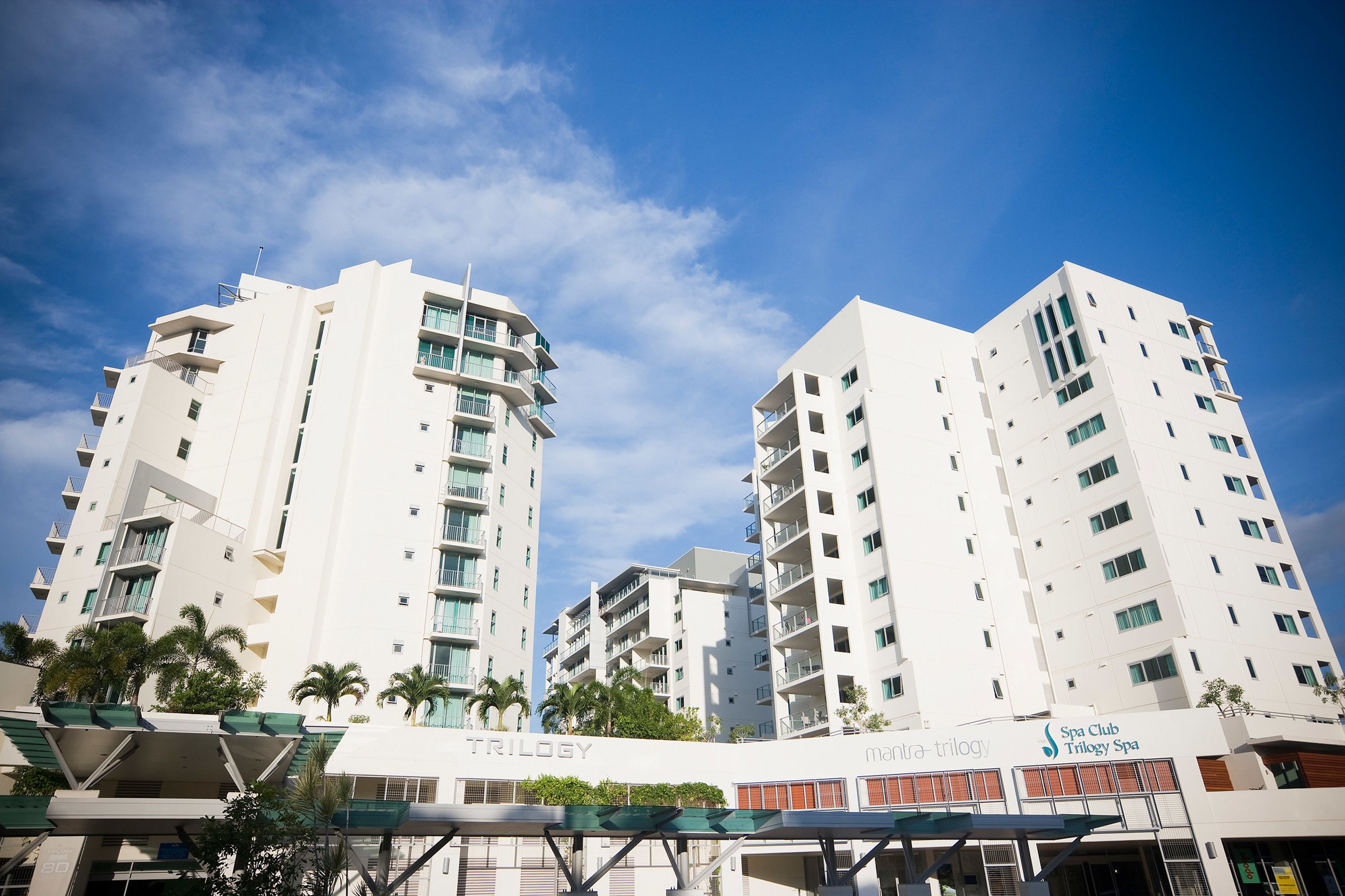 A modern hotel with multiple floors, balconies, and a spa club named 'TRILOGY'.