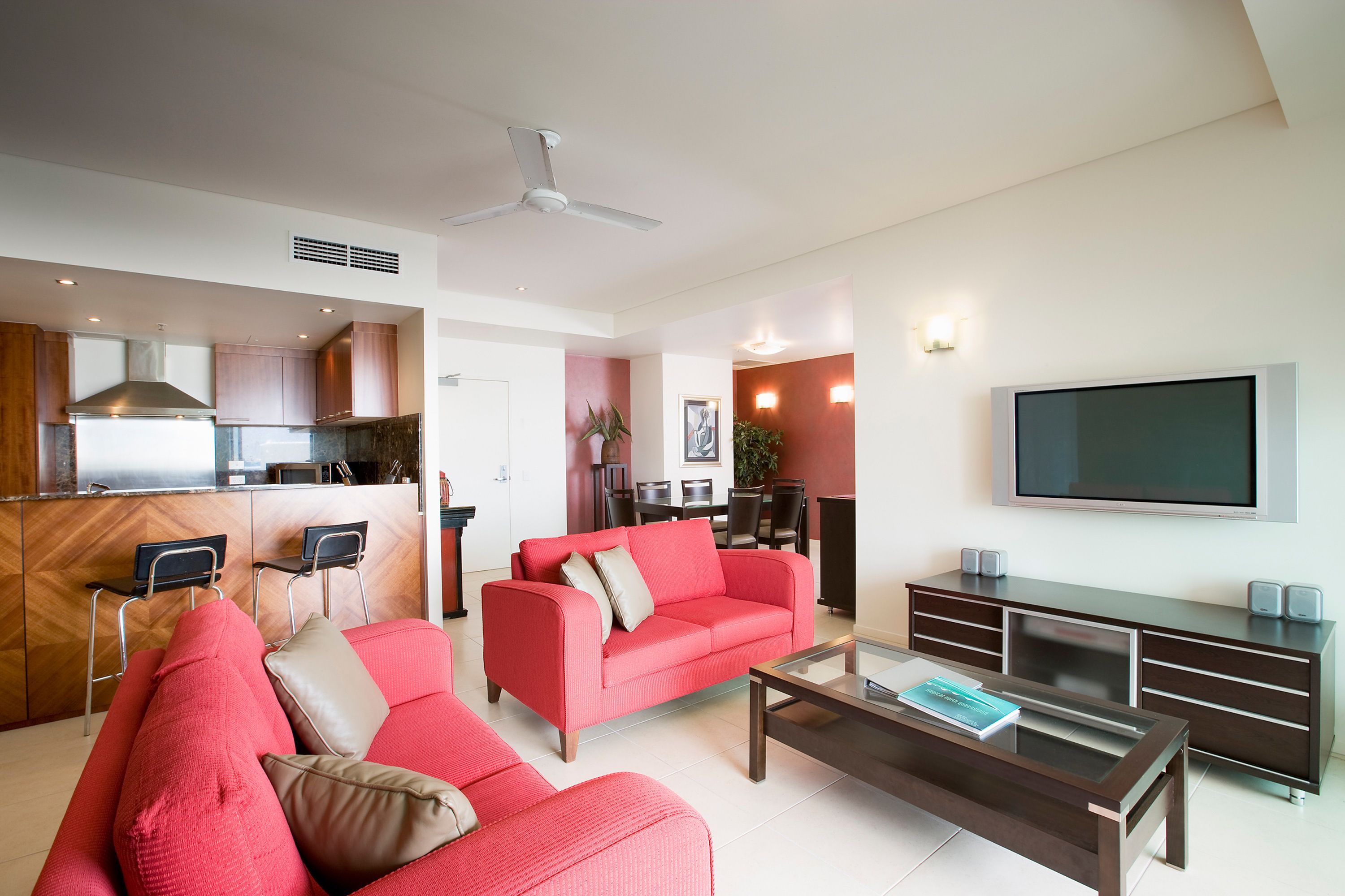 Ein modernes Wohnzimmer mit einem roten Sofa, einem Couchtisch und einem Fernseher.