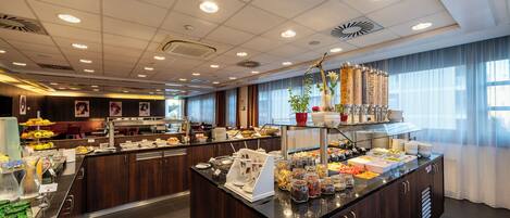A buffet area with various food items and a coffee station.