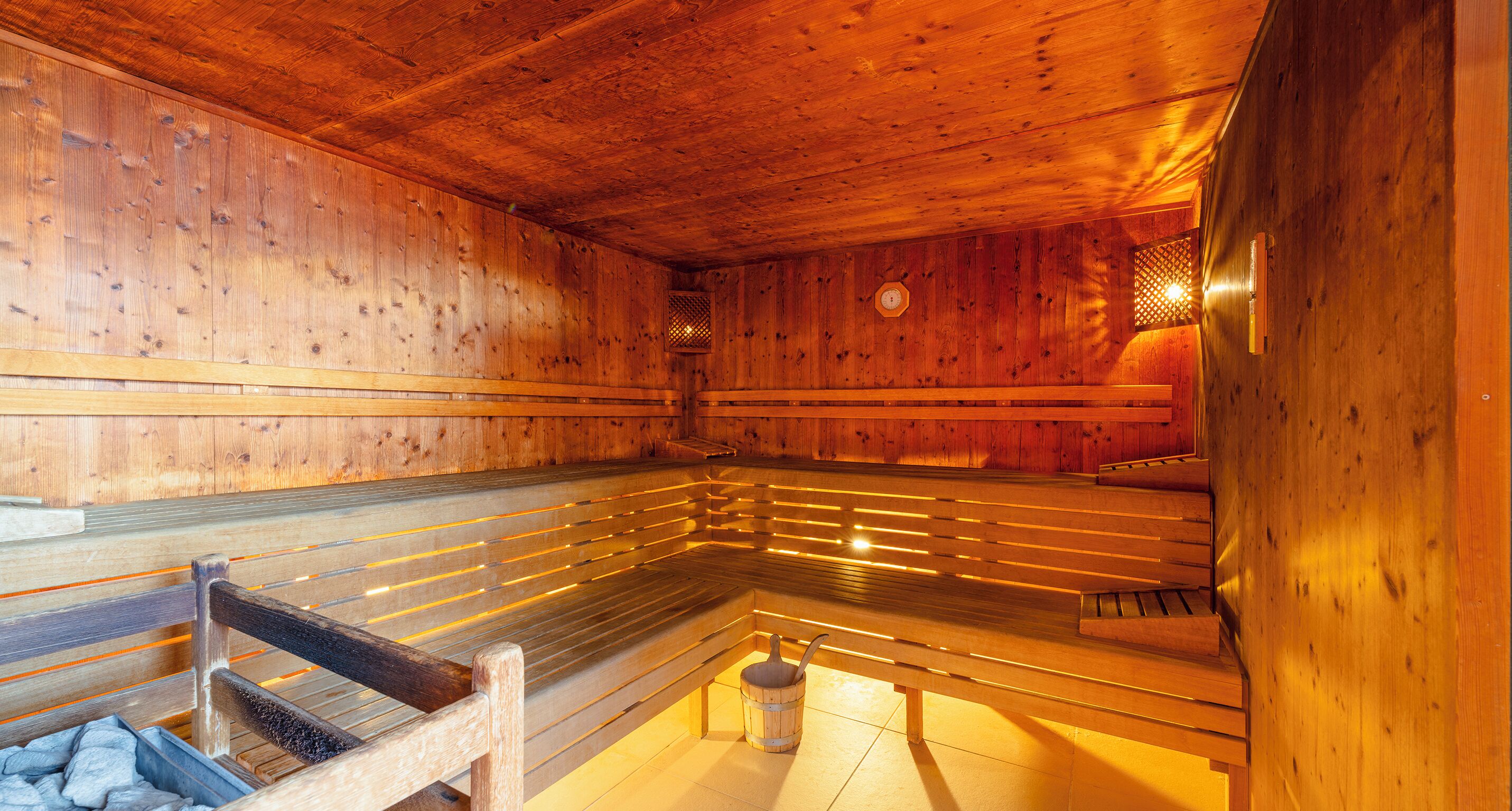 Una sauna con panche in legno e una vasca in pietra.