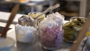 Una mesa con diversos alimentos en recipientes de vidrio, incluyendo lo que parece ser helado y pepinillos.