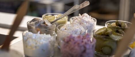 A table with various food items in small glass containers, including what appears to be ice cream and pickles.