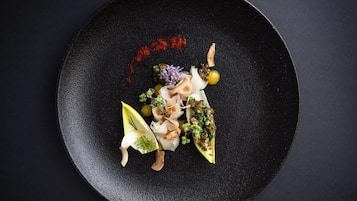Un plato negro con diversos alimentos y guarniciones.