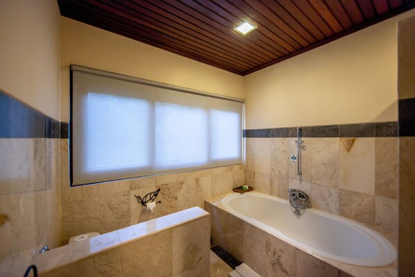 A bathroom with a bathtub, a toilet, and a large mirror. - The Payogan Villa Resort & Spa Ubud (Ubud)