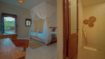 Un dormitorio con cama con dosel, una mesa de madera y vistas al verdor exterior.