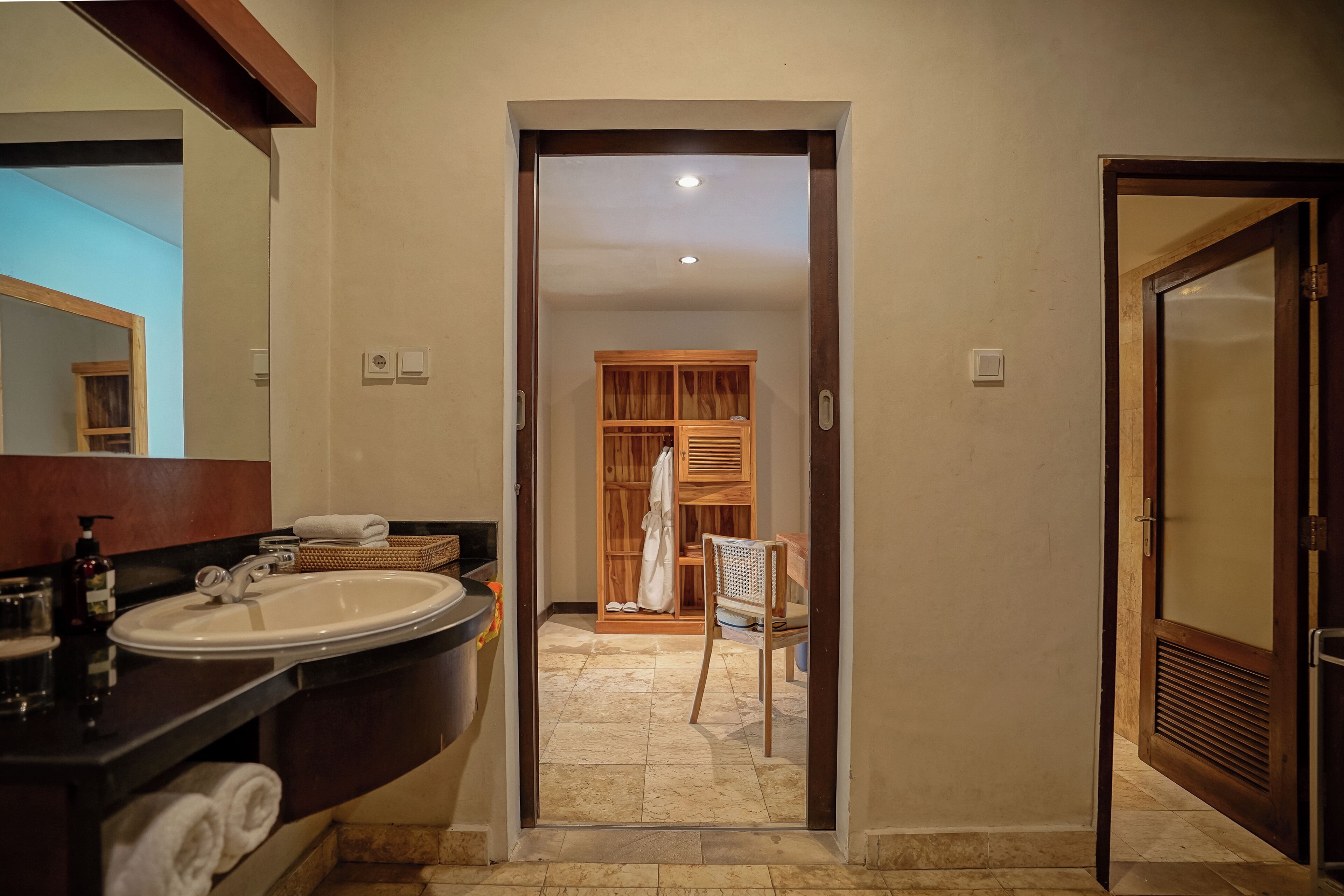 A bathroom with a sink, mirror, and wooden cabinet.