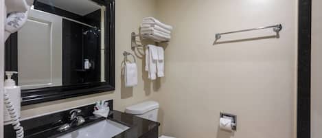 A bathroom with a black sink, white toilet, and a towel rack.
