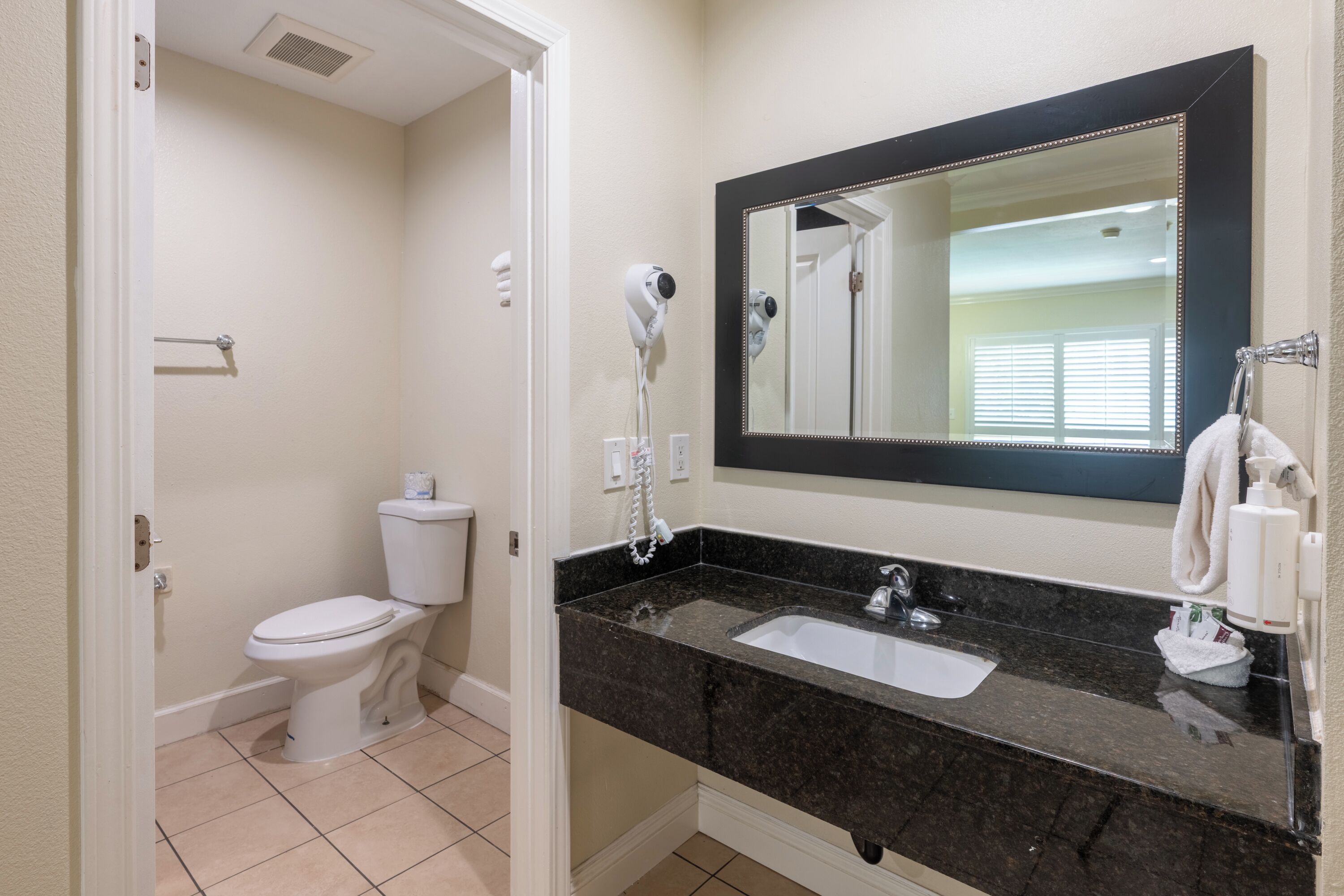 Un baño con inodoro, lavabo y espejo.