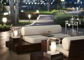 Relax in the serene garden setting, surrounded by a comfortable bench and elegant tables.