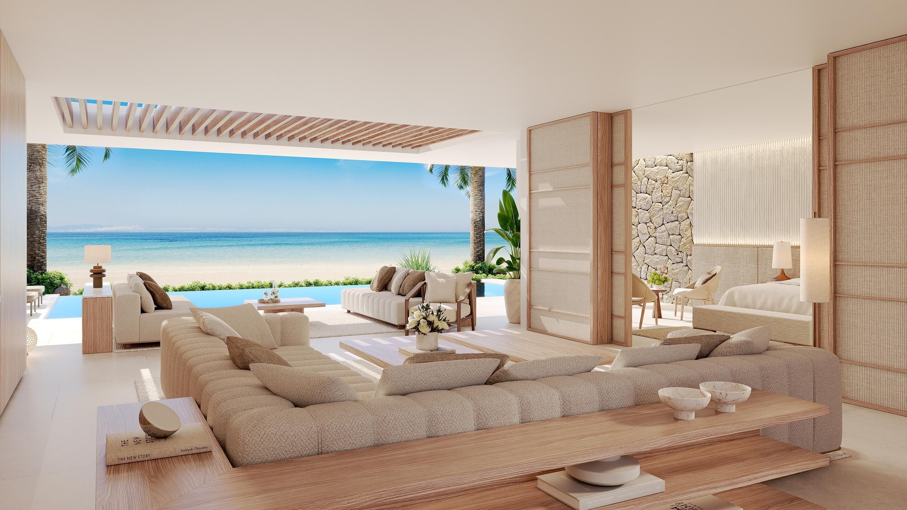 Una sala de estar moderna con un sofá grande, una mesa de centro y vistas a la playa.