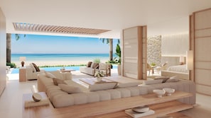 A modern living room with a large sofa, a coffee table, and a view of the beach. - Sani Asterias (Kassandra)