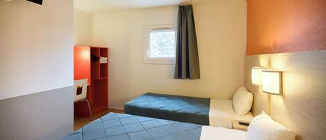 A hotel room with two beds, a desk, a chair, a wardrobe, and a window with curtains.