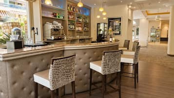 Eine Bar mit einer Theke, Barhocker und Regalen voller Flaschen.