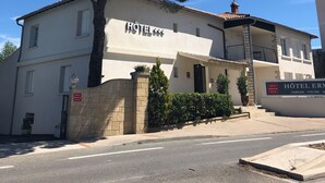 A two-story building with a sign that reads "HOTEL ERNESTINE." - Hôtel ERMITAGE (Les Angles)