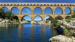 A stone bridge with multiple arches over a river. - Hôtel ERMITAGE (Les Angles)