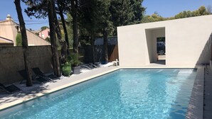 A rectangular swimming pool with clear blue water, surrounded by lounge chairs and potted plants. - Hôtel ERMITAGE (Les Angles)