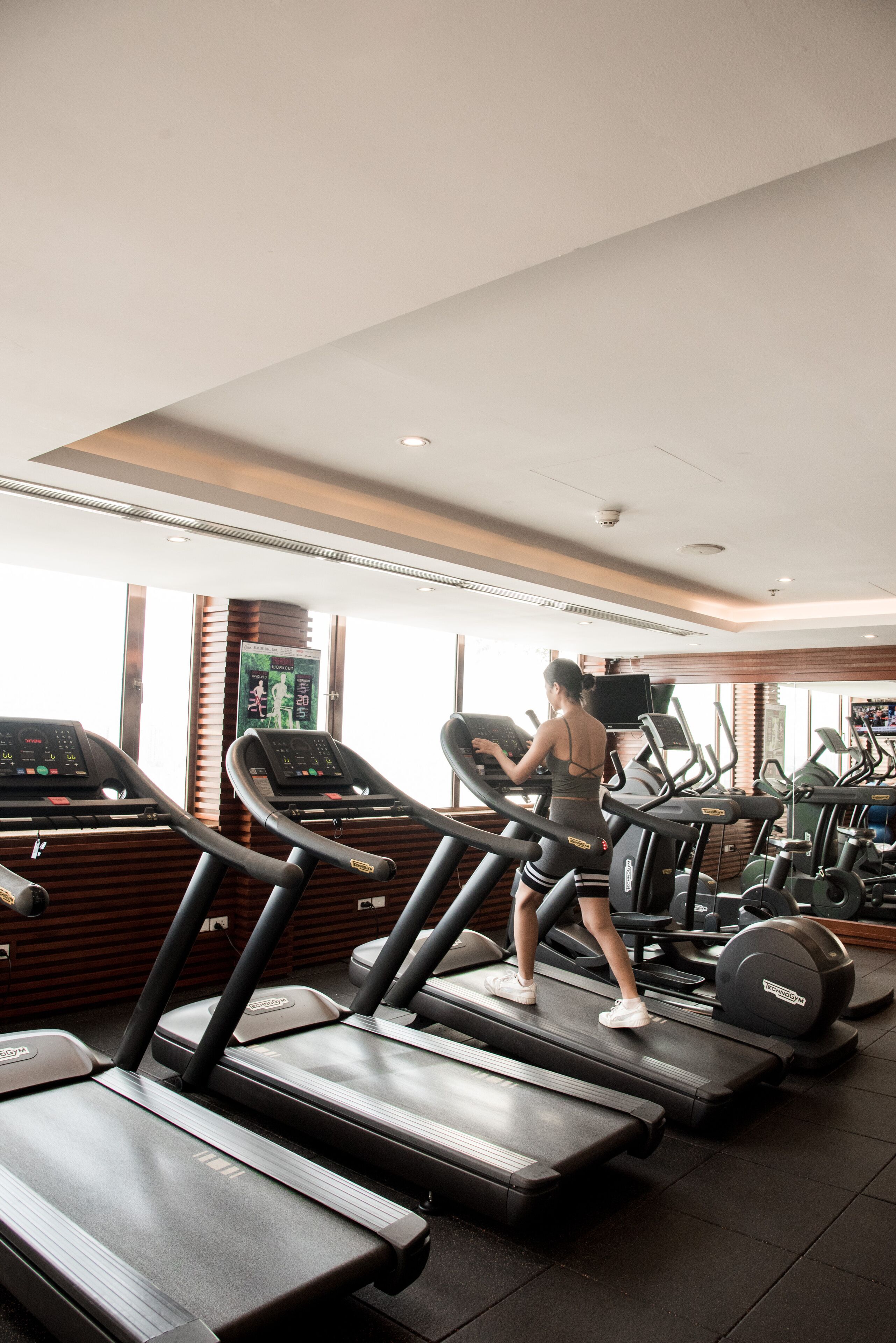 Une salle de sport équipée de tapis de course et d'appareils d'exercice.