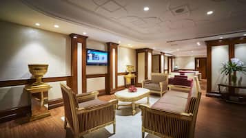 A luxurious lobby with ornate furniture, a television, and decorative vases.