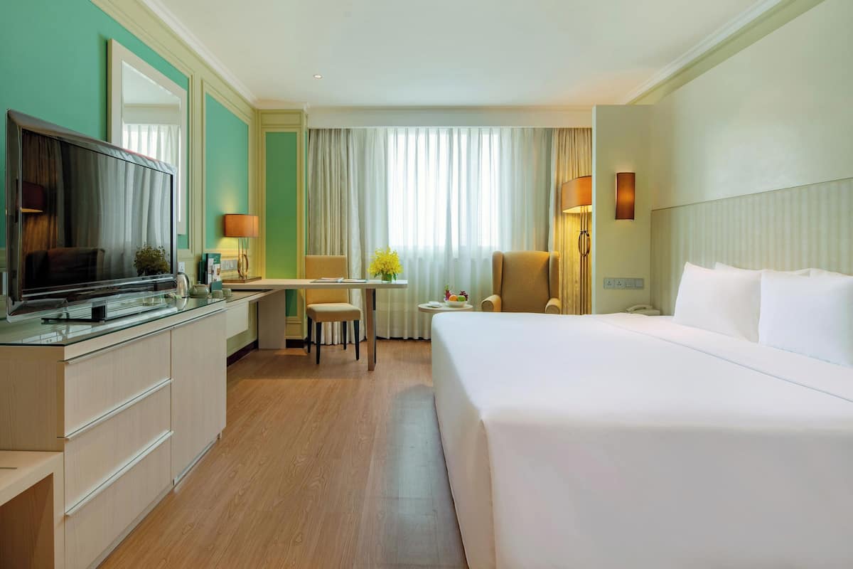 Une chambre d’hôtel dotée d’un grand lit, d’un bureau, d’une télévision et d’un coin salon.