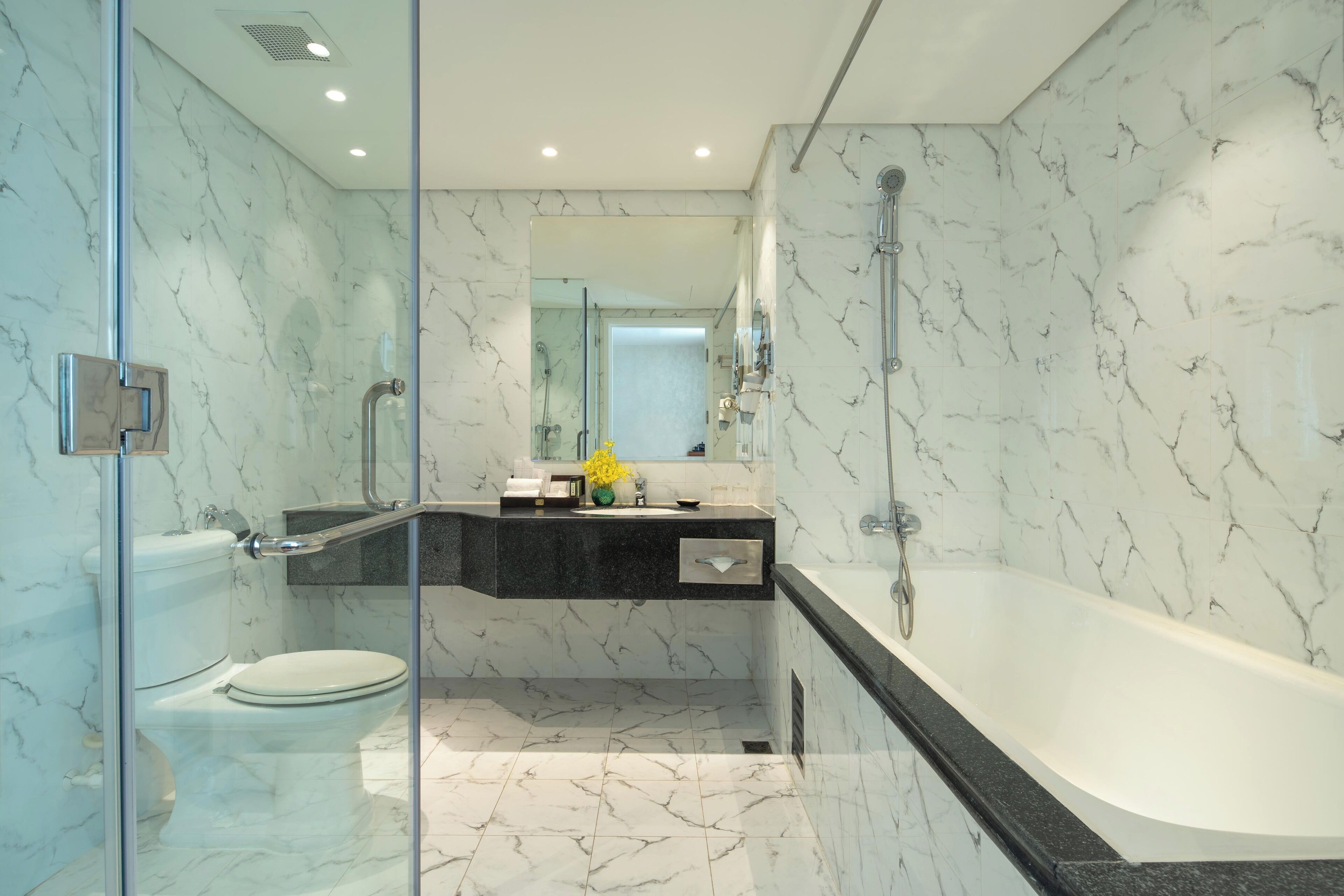 A modern bathroom with a glass-enclosed shower, a toilet, a sink, and a bathtub.