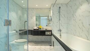 A modern bathroom with a glass-enclosed shower, a toilet, a sink, and a bathtub.