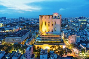 Un grand hôtel à plusieurs étages, avec une enseigne bien visible au sommet et une façade bien éclairée.