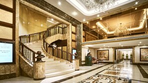 A grand lobby with a marble staircase, chandeliers, and a large mirror reflecting the space. - Windsor Plaza Hotel (Ho Chi Minh City)