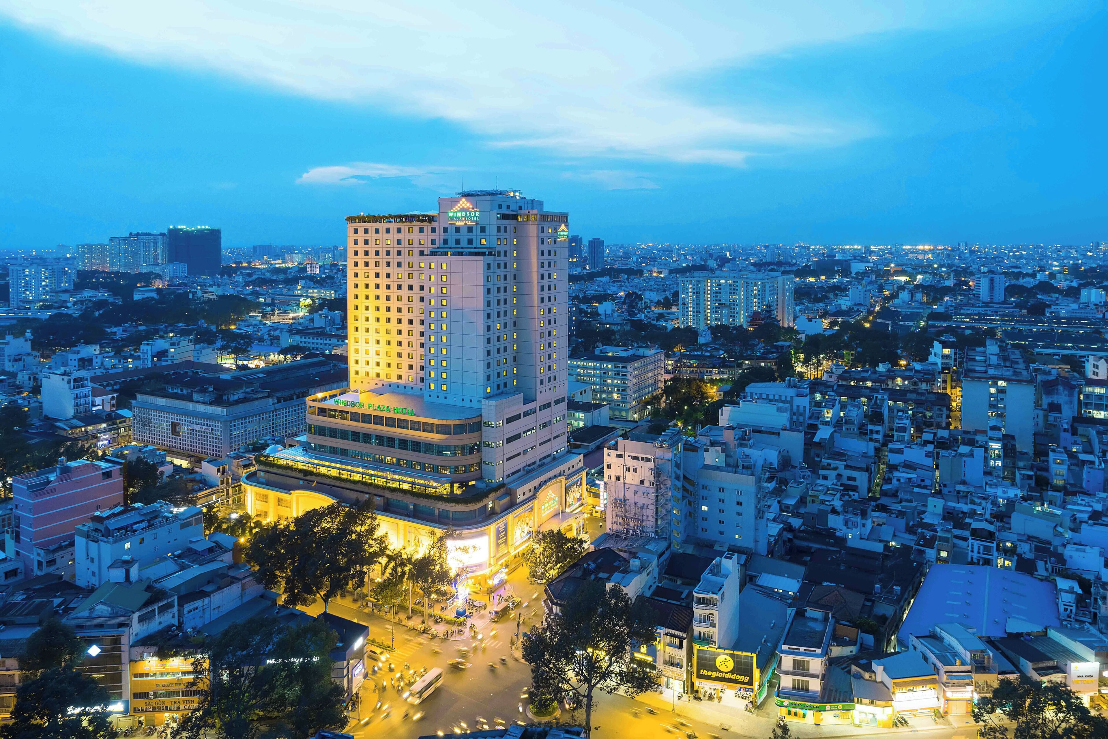 A high-rise hotel with multiple floors, surrounded by a densely populated urban area with various buildings and streets.