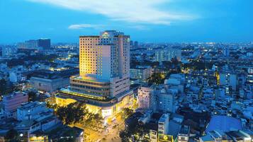 A high-rise hotel with multiple floors, surrounded by a densely populated urban area with various buildings and streets.
