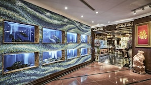 A lobby with a mosaic wall, multiple aquariums, a reception area, and a statue. - Windsor Plaza Hotel (Ho Chi Minh City)