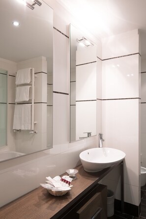 A modern bathroom with a large mirror, a white sink, and a towel rack. - Hotel Da Vinci (Vinci)