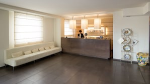 A modern hotel lobby with a reception desk, a sofa, and a decorative plate rack.