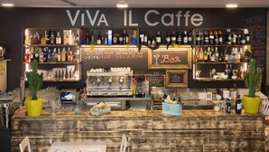 A bar area with a wooden counter, various bottles, and a menu board.