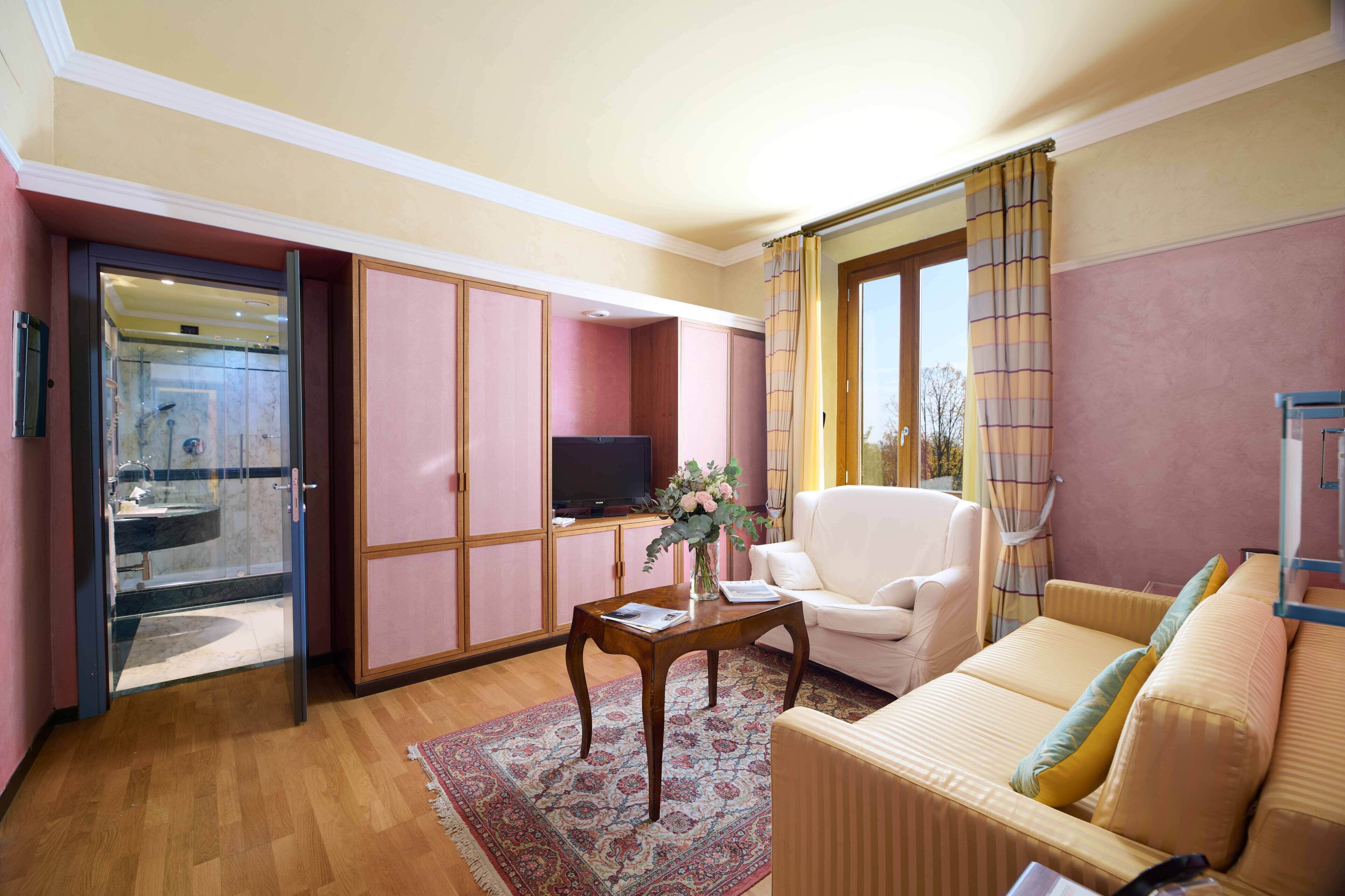 A living room with a sofa, armchair, and a coffee table with a vase.